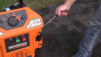 Woman is pulling the starter cord of the gas pressure washer.