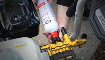 Applying the pump saver to the pressure washer.